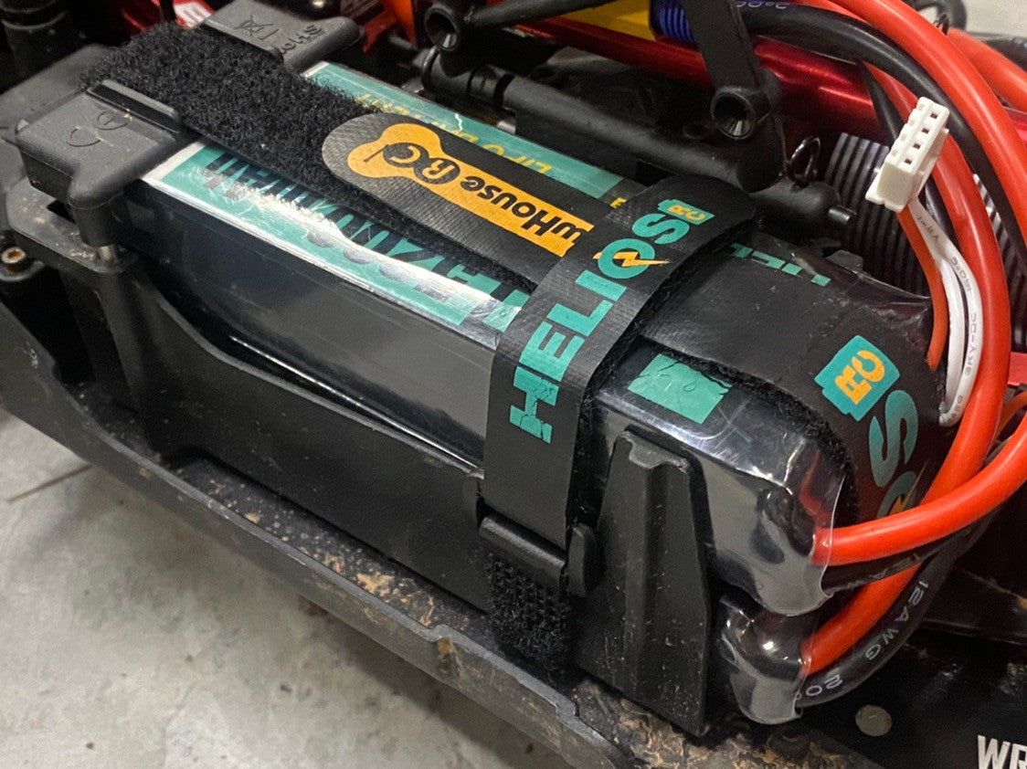 A close-up image of a battery strap set installed on a RC car battery, with a focus on the non-slip coating and the attached wiring.
