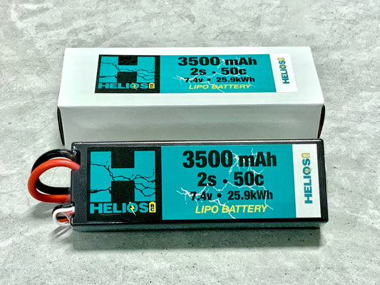 Two Helios 2S 3500 mAh 50C Lipo batteries, one standing upright and the other lying horizontally, with visible branding and capacity details on the labels.